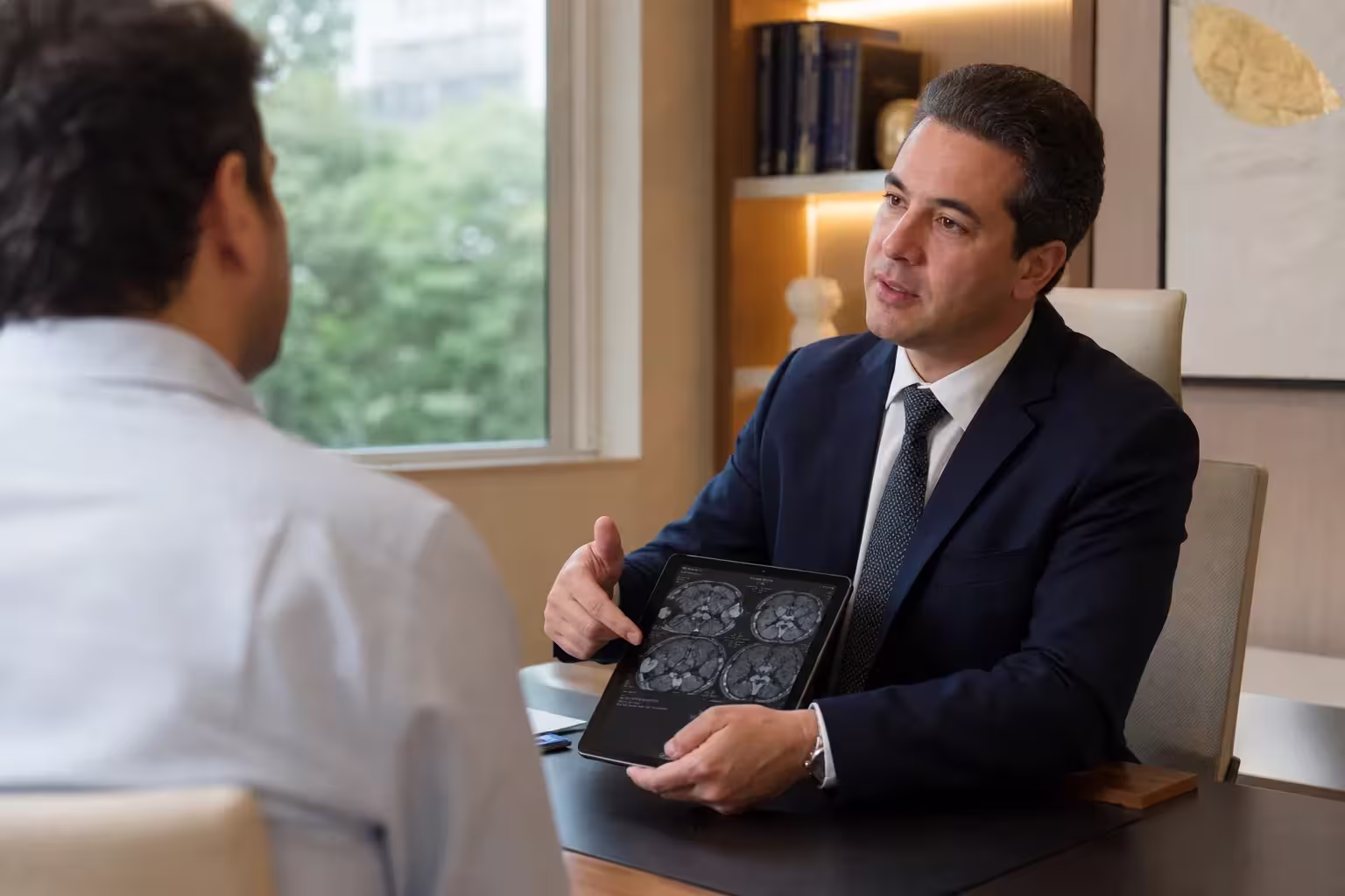 Cirurgião do aparelho digestivo conversando com um paciente em consulta
